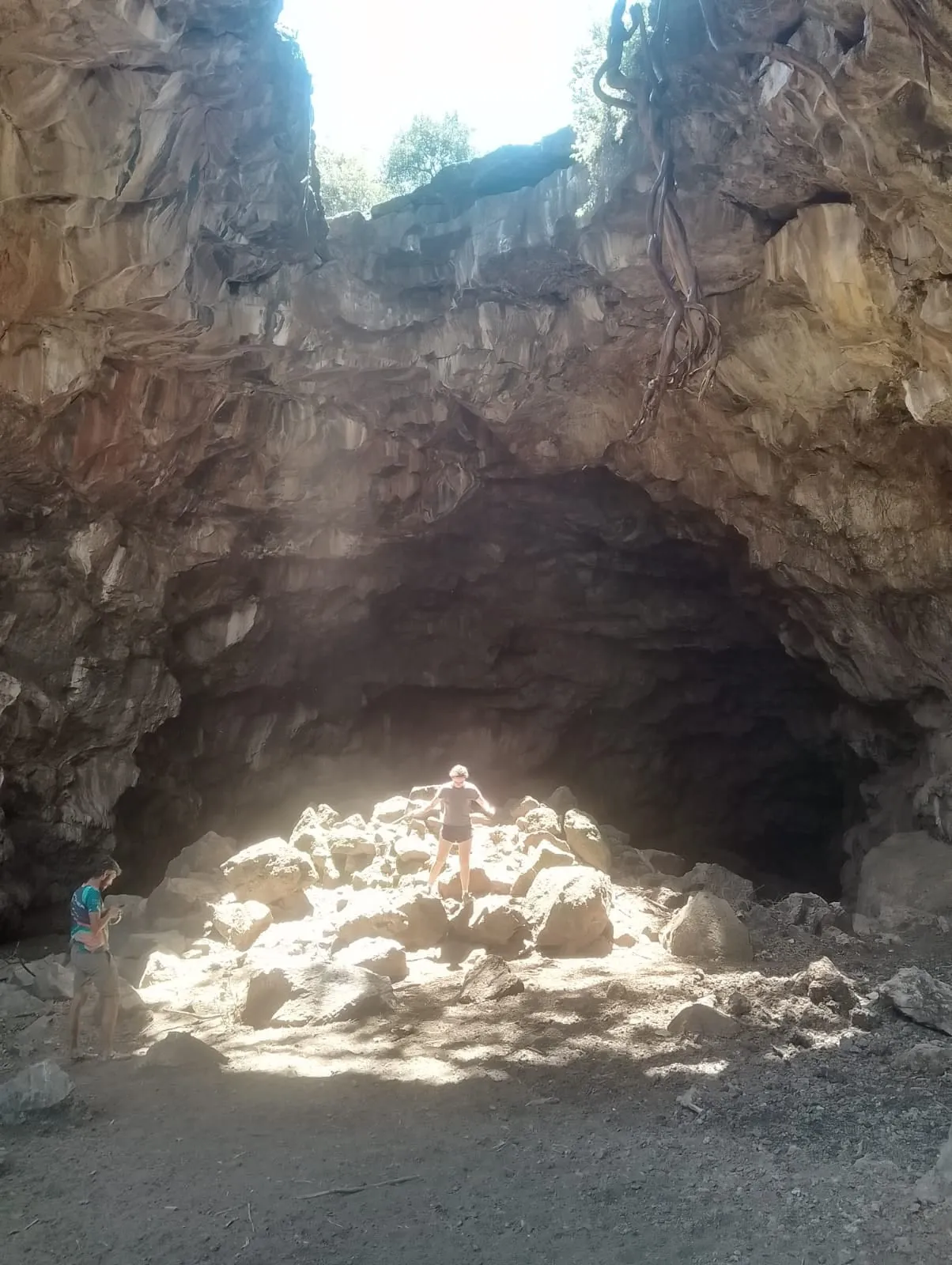 A guest standing in the light that falls through the cave roof