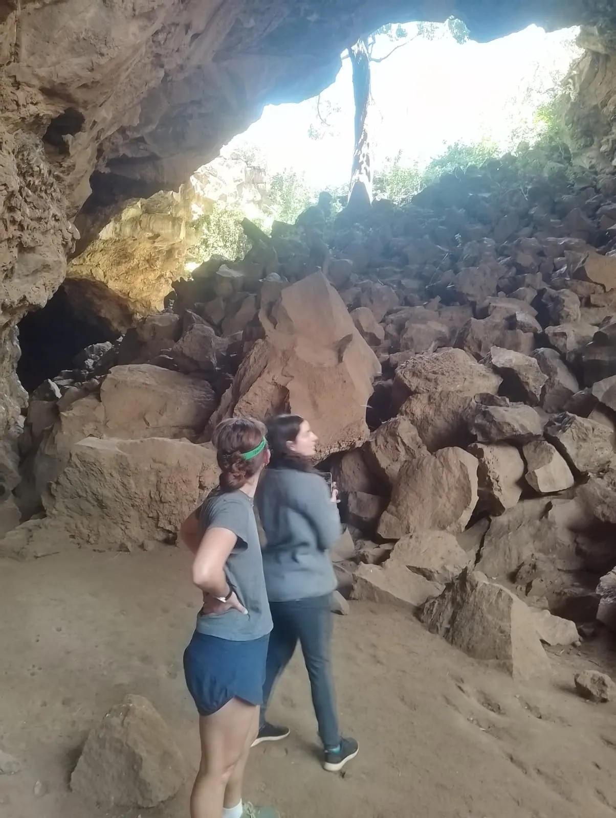 Two guests looking up at the rocks inside a cave