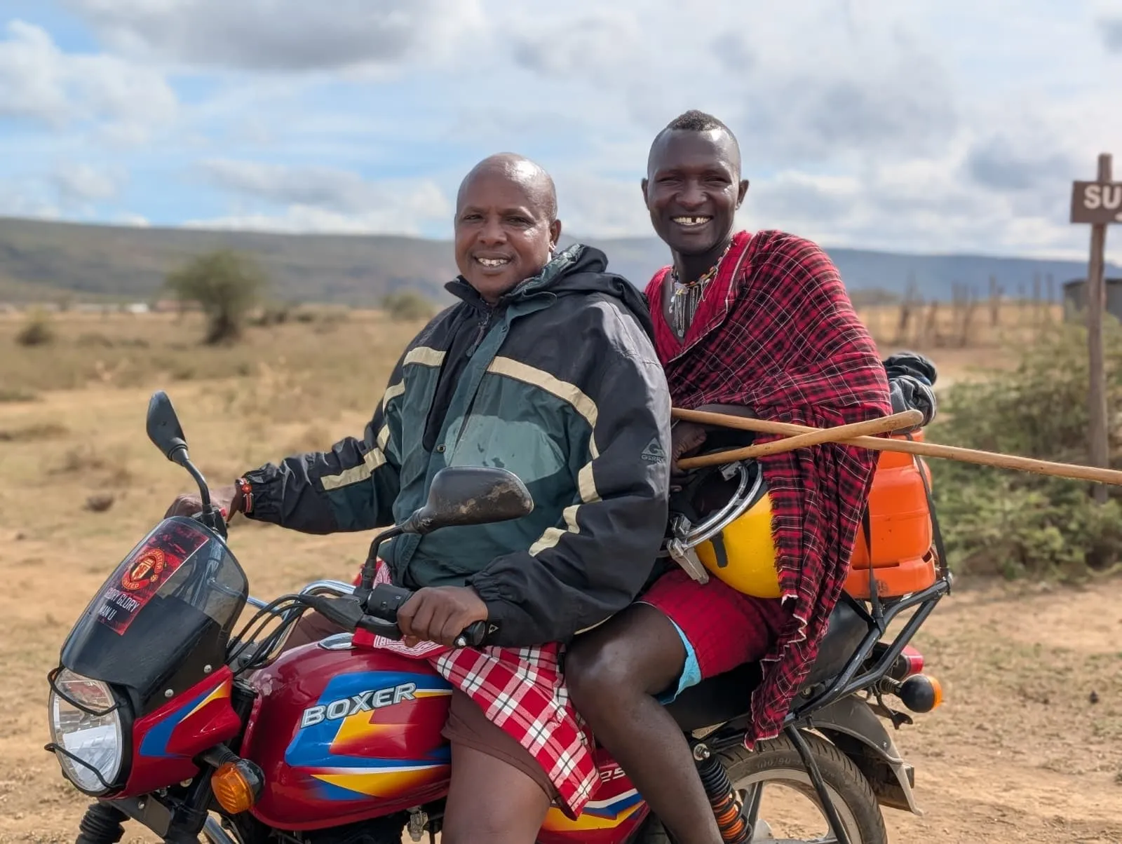 Daniel and Timothy on their motorbike by the Mount Suswa sign