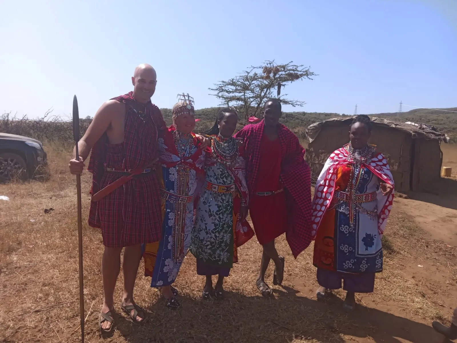 Guests in Maasai dress with a Maasai family at their homestead