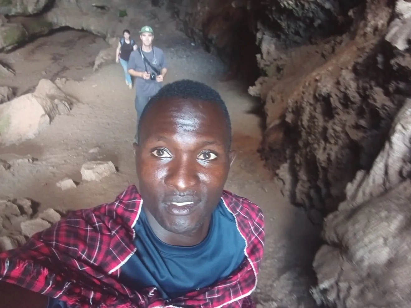 Timothy in a lava cave with a guest behind him